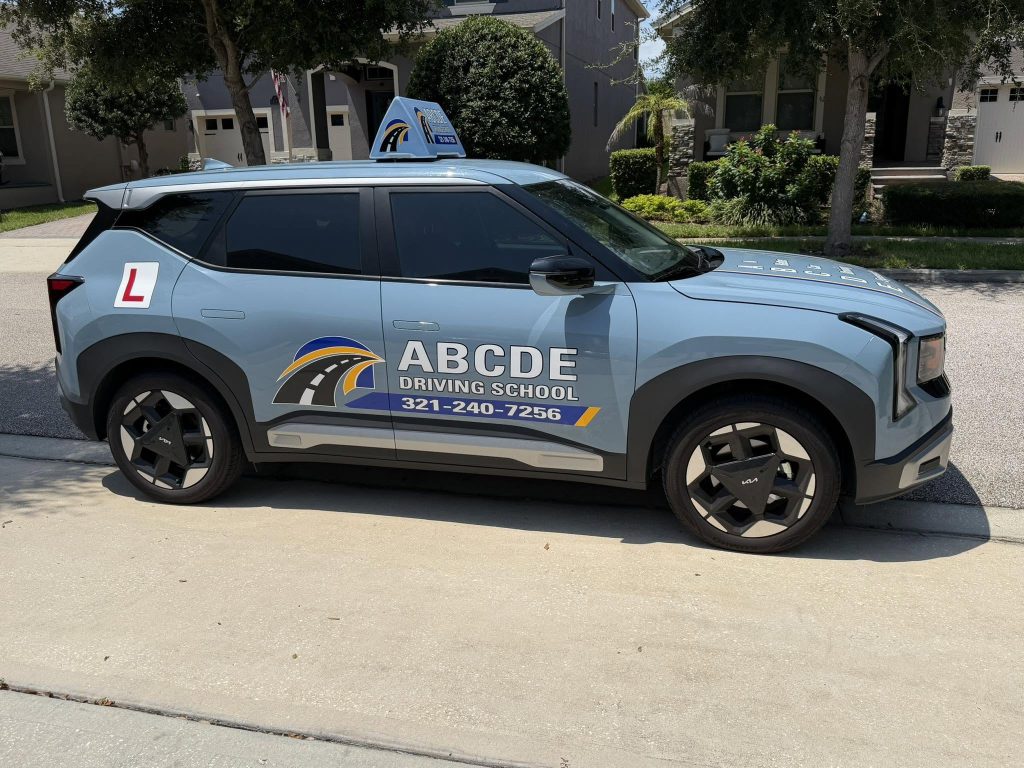 Blue ABCDE Driving School Kia Seltos with branded door signage and learner roof sign